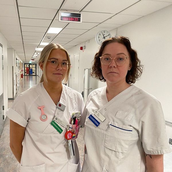Undersköterskan Erika Karlsson och sjuksköterskan Sara Karlsson Stjärnholm står i en korridor på Kullbergska sjukhuset i Katrineholm.
