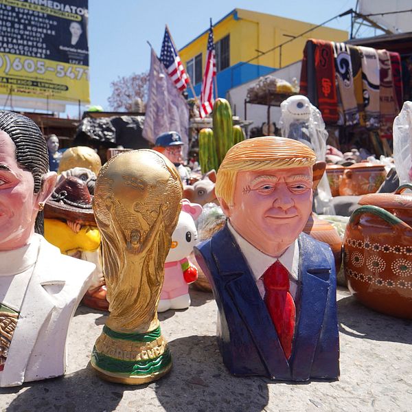 Fotbolls-VM:s värdnationer USA, Kanada och Mexiko avbildade som figurer med VM-pokalen