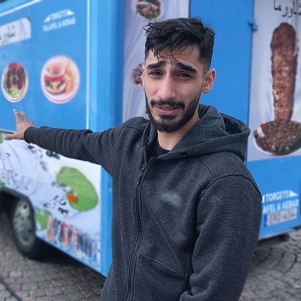 Man vid kebabvagn på torg
