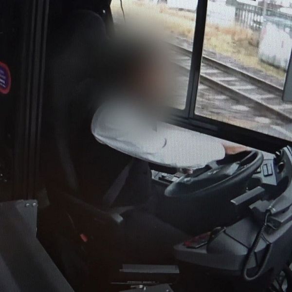 Oskarp bild av bussförare i förarhytten.
