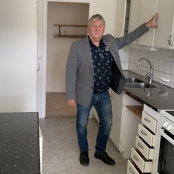Greger Lindqvist som är kommunalråd i Dorotea står i en tom lägenhet med ett allvarligt ansiktsuttryck.