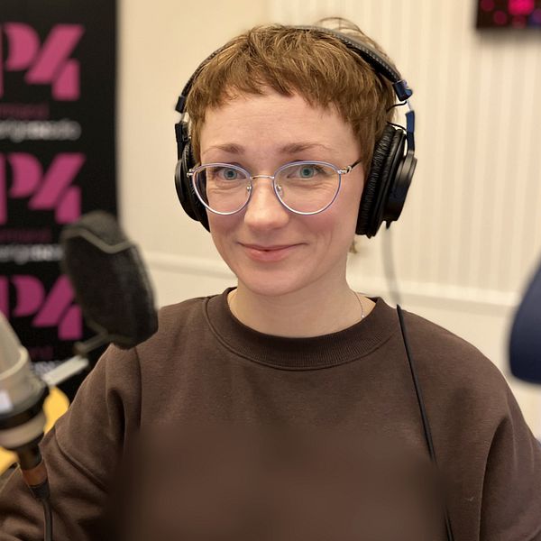 kvinna med hörlurar i radiostudio