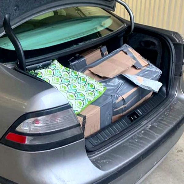 Bagageluckan på den silvergråfärgade bilen är öppen och kartongerna som innehöll 55 kilo amfetamin blottas.