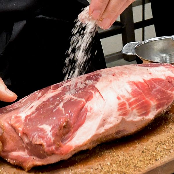 Kött saltas under en matlagningskurs.