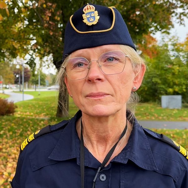 Johanna Hennix, lokalpolisområdeschef i Kungsbacka står framför ett område med färgglada höstlöv och en grön park i bakgrunden.