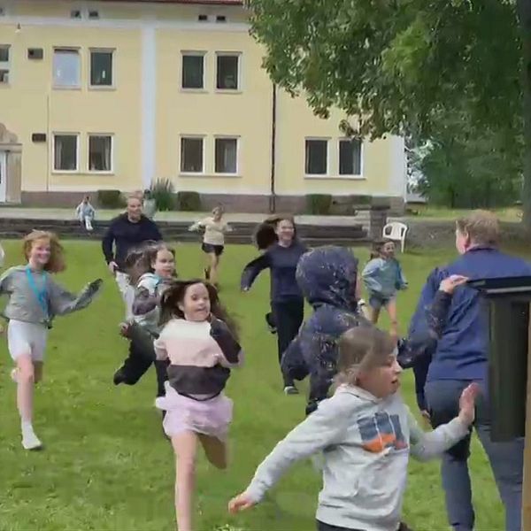 Barn och lägerledaren springer på gården