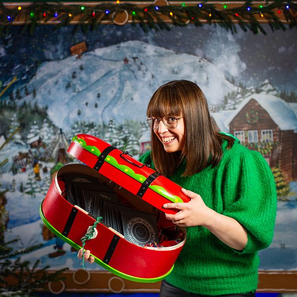 Programledaren Marit Kuhmunen Blom visar sin skattkista som ska fyllas med samiska berättelser i samiska lucköppning av årets julkalender.