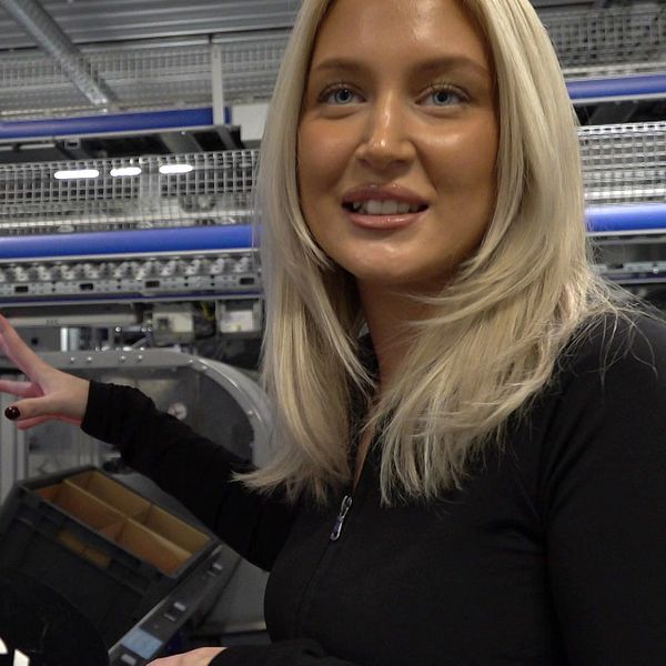 Unga Linn i Vansbro står vid en datorskärm i fabriken och berättar om arbetet.