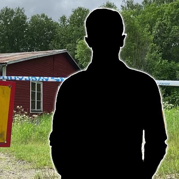 En avspärrad väg med en gul skylt som säger ”AVSPÄRRAT” hänger i förgrunden, framför en röd byggnad. Bakom skylten syns en oklar silhuett av en person.