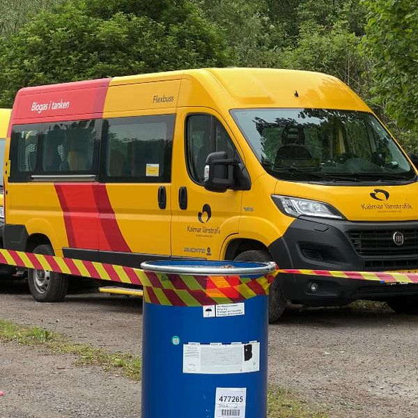 Två minibussar gulfärgade med KLT:s färger bakom en avspärrning