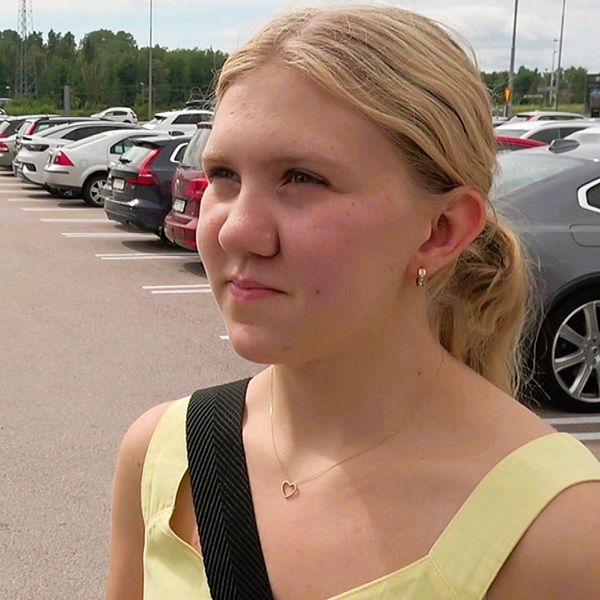 En kvinna blir intervjuad på en parkeringsplats