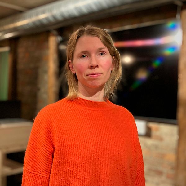 Johanna Barr, kvinna med orange tröja står i en lokal där de nyss hållit en infokväll om gruvplanerna i Jämtland.