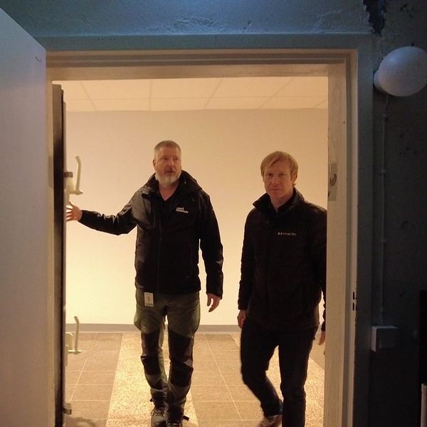 Andreas Figaro, säkerhetssamordnare, och reporter Per-Anders Fredriksson går in i ett mörkt skyddsrum.