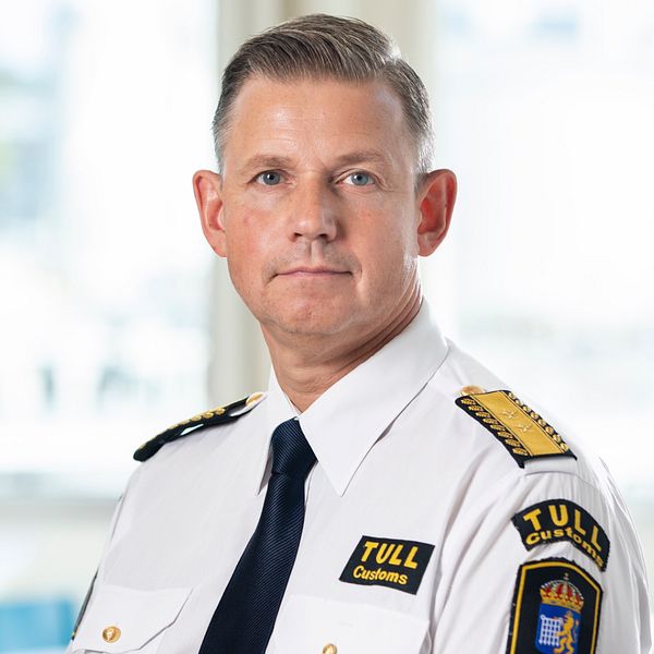 En man i uniform står framför kameran