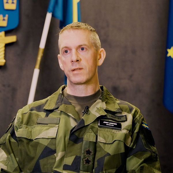 arméchefen Jonny Lindfors framför en svensk flagga