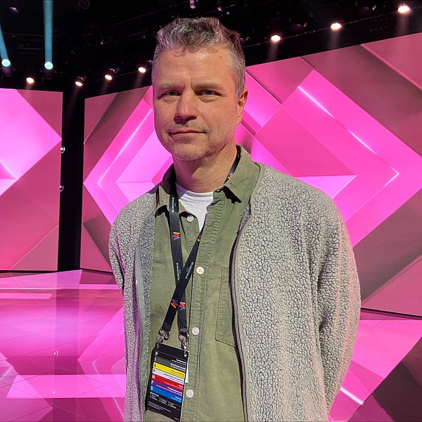 Melodifestivalens projektledare står på scenen och tittar in i kameran