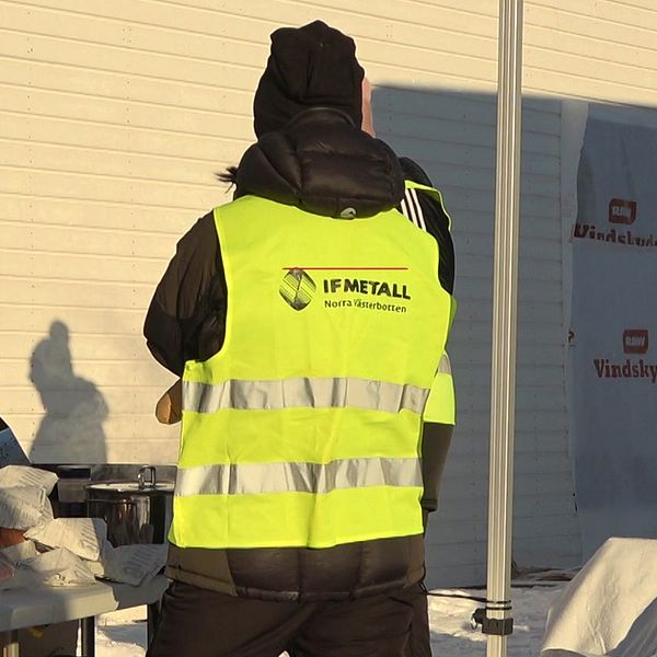 Personer i gula västar där det står ”IF Metall” står utomhus