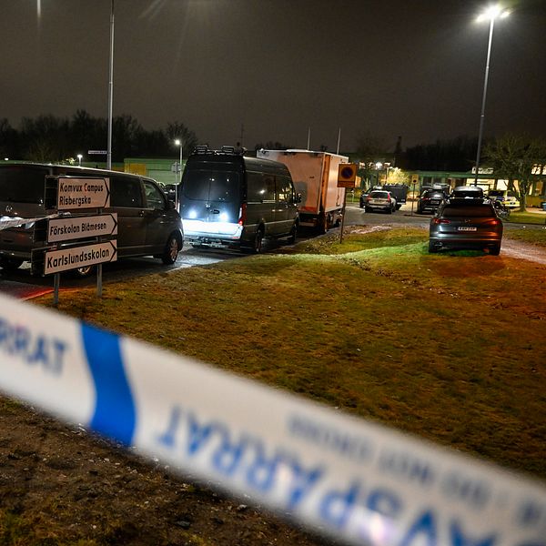 polisbilar som står innanför avspärrningsband
