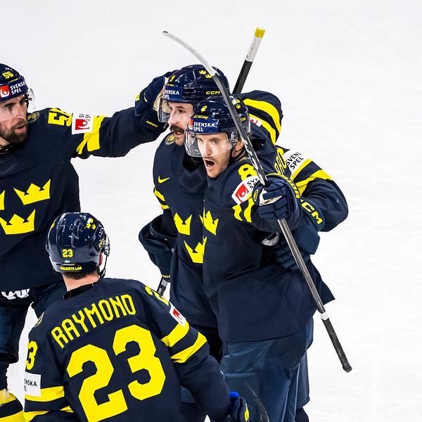 Tre Kronor-spelare firar tillsammans på isen efter en målchans i ishockeymatch.