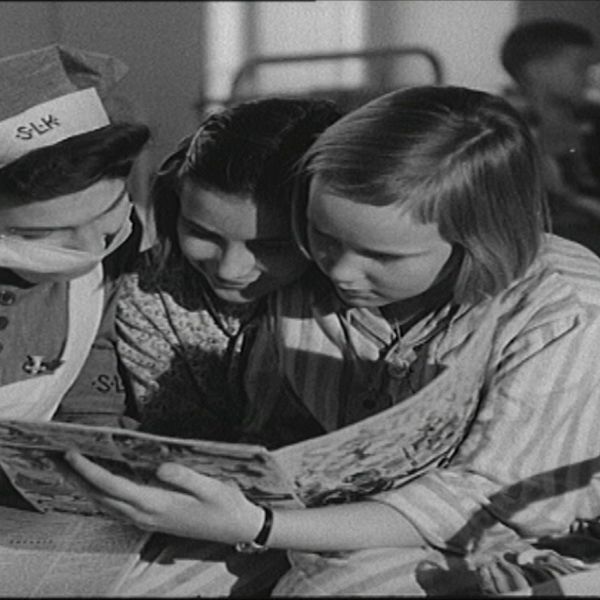 Krigsbarn läser en bok tillsammans med en sköterska.