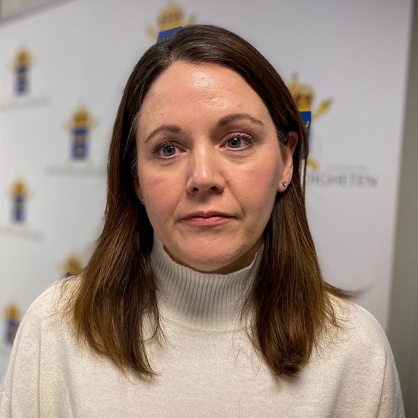 En kvinna framför åklagarmyndighetens logo