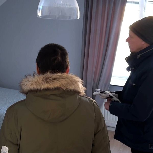 Två personer står och tittar på en säng i ett rum på Skellefteås nya härbärge-