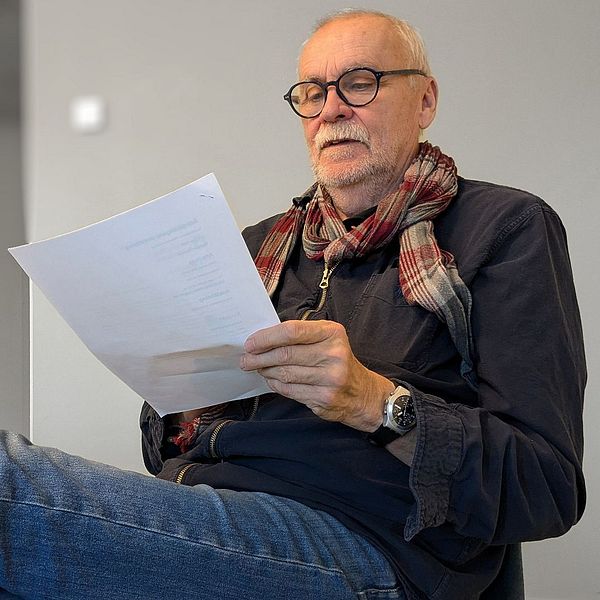 Anderz Andersson sitter på en stol i ett grått grupprum i Umeå universitet och läser igenom Skellefteå kommuns udda jobbannons på utskrivet papper.