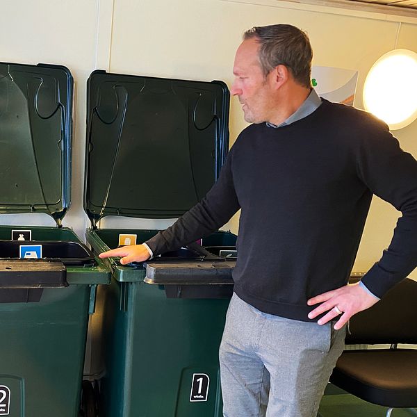 Andreas Boström, ordförande WBAB, står vid två av de nya sopkärlen som har flera små kärl för olika sorters avfall.