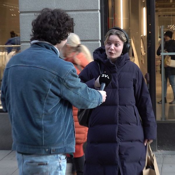 Kvinna med lång blå jacka