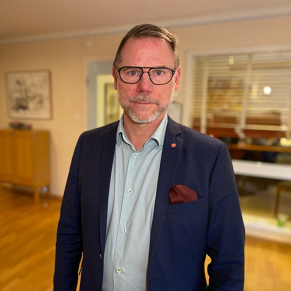 Andreas Svahn (S), ordförande i regionstyrelsen, klädd i en mörkblå kostym, men ljusblå skjorta. Bakom honom syns ett fönster med persienner in till ett kontor.