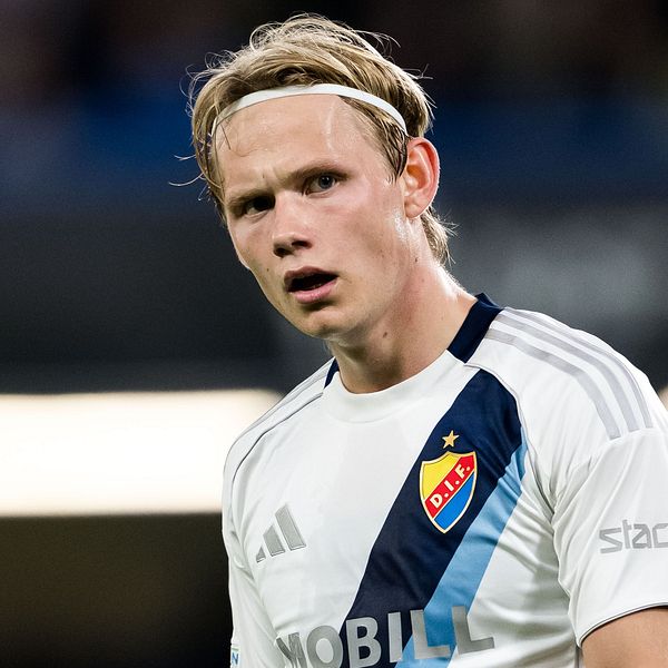Fotbollsspelare i Djurgårdens IF:s vita matchtröja på planen under en match.