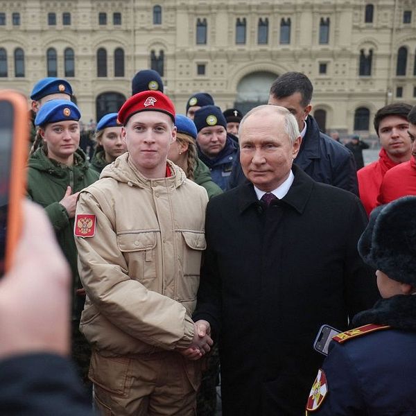 Vladimir Putin skakar hand med en soldat i Moskva.