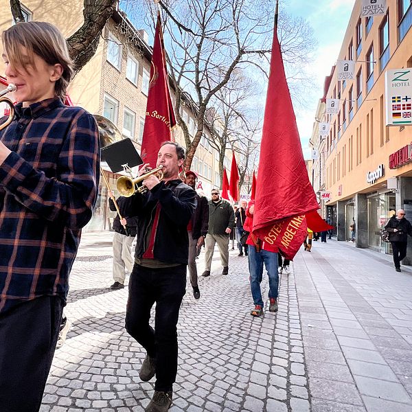 Trumpetare går i förstamajtåg genom Östersunds stadskärna.