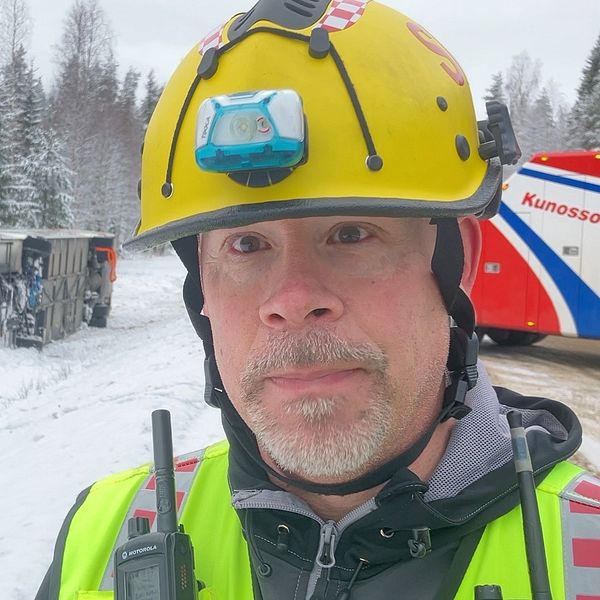 Räddningsledaren Lennart Stenman framför den omkullvälta bussen utanför Norsjö
