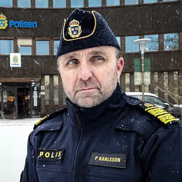Polisman står utanför polishuset i Falun och det snöar.