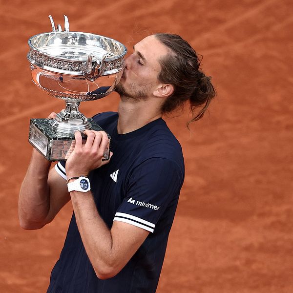 Tennisspelare firar med en pokal på grusbanan i Paris