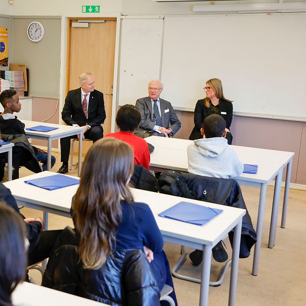 Kungen i ett klassrum med elever på skola.