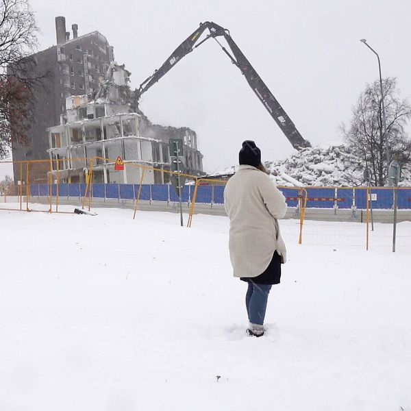 Hus som rivs i Kiruna och kommunantikvarie Clara Nyström tittar på.