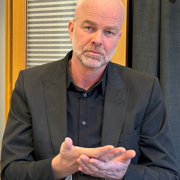 Anders Silvetärn sitter i ett mötesrum och tecknar ordet tolk.