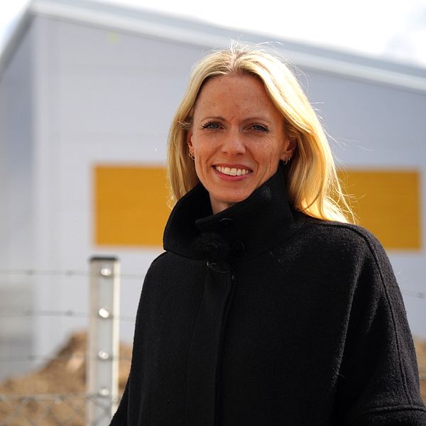 Blond kvinna står framför byggprojekt