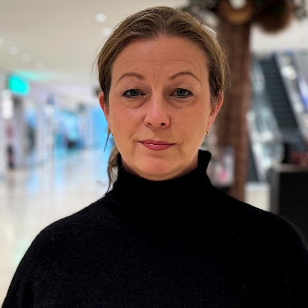 En person står framför en gång i ett köpcentrum, med butiker på båda sidor. Belysningen är mjuk och belyser den moderna, öppna miljön. Bakom personen kan man se displayer och skyltar från olika affärer. Jessica Wikestam är marknadschef på Kungsmässan och berättar om hur rutinerna gick till vid skottlossningen.
