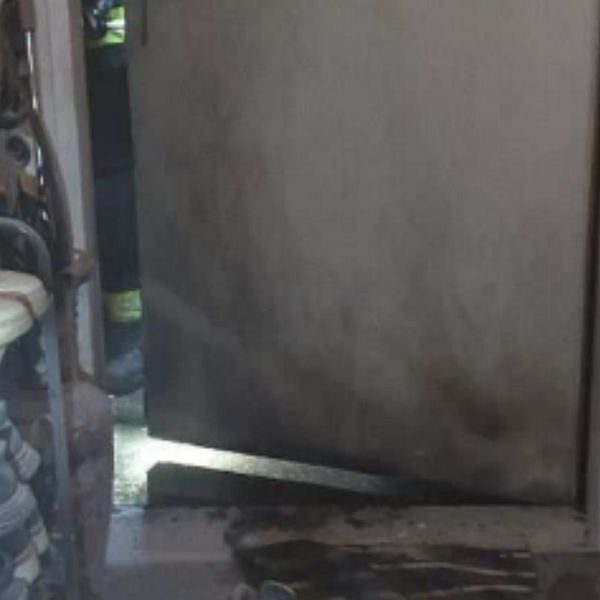 Delad bild: Första sektionen visar en brandskadad ventilation mot en träpanel, belyst av en ficklampa. Andra sektionen visar en sotig dörr med ljus som skiner in från botten.