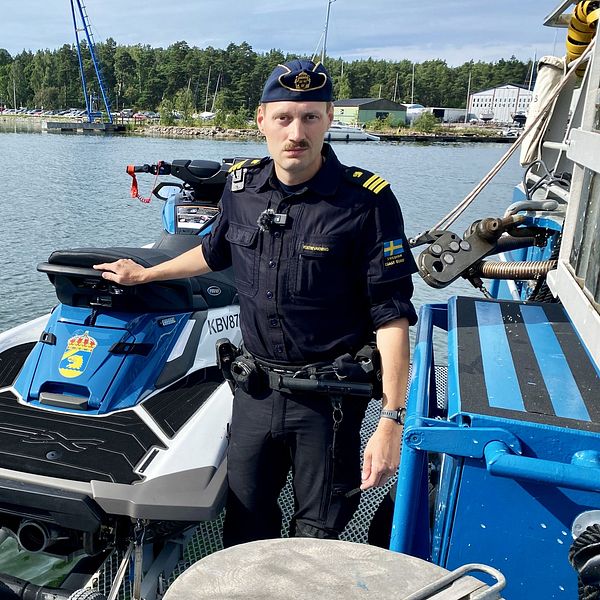Kustbevakningsman bredvid vattenskoter.