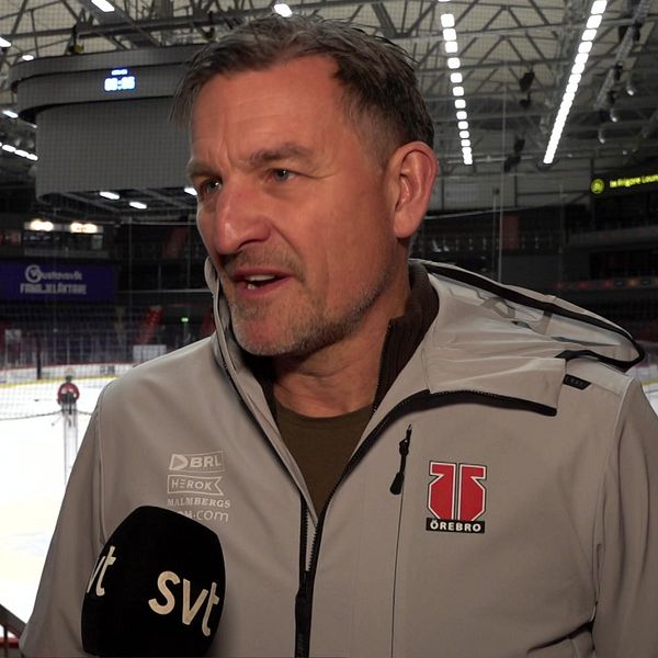 Till vänster syns Johan Hedberg i kort hår, glasögon pekandes mot bilden. till höger står Stefan Bengtzén, general manager för Örebro hockey.