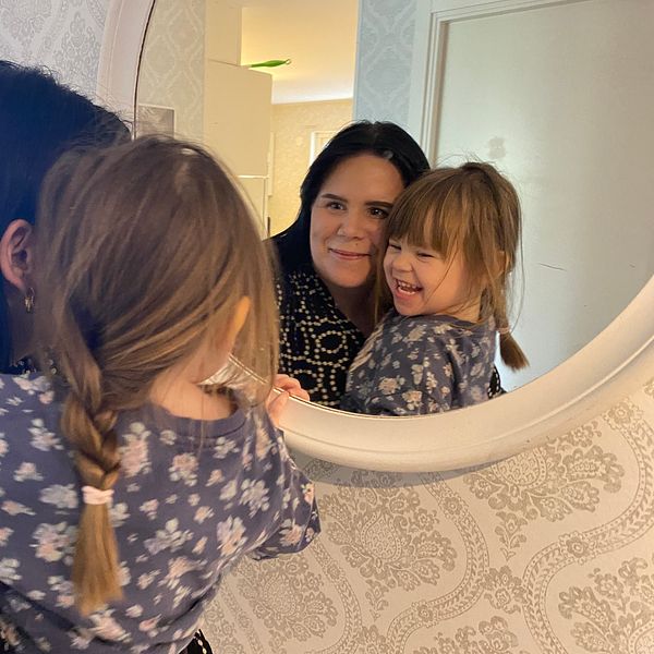 Selma 2,5 år tittar i en spegel tillsammans med mamma Alexandra.