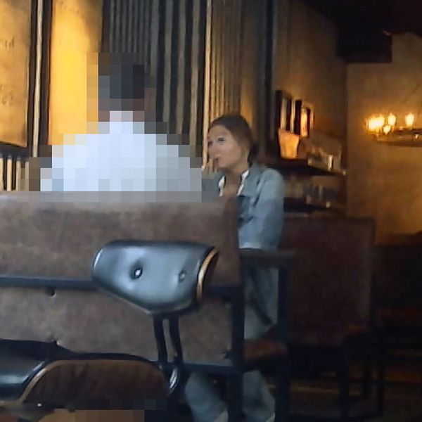 Stillbild från dokumentären Köp mina trosor, reportern Nellie Erberth sitter på ett café mittemot en pixlad person.