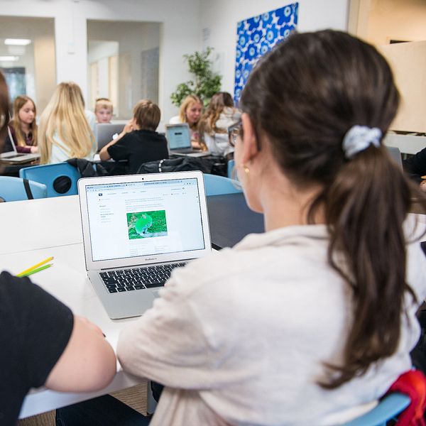 Skolelever framför datorer i klassrum.