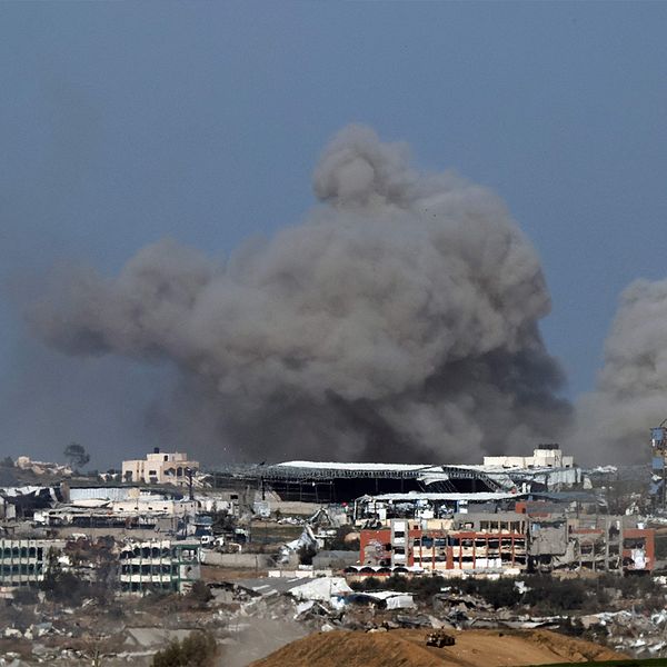 Migrationsverket-skylt och ett rökmoln över Gaza