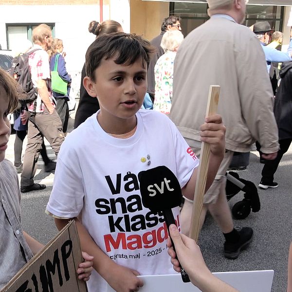 Två ungdomar på 1:a maj demonstration intervjuas av SVT-reporter bland andra deltagare på gatan.