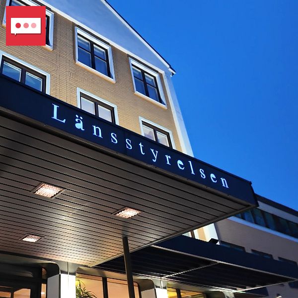 Fasad av en byggnad med skylten ”Länsstyrelsen” ovanför en ingång och kvällshimmel i bakgrunden.